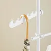A close-up view of a white coat rack with an umbrella hanging from one of its hooks. Náhľad obrázku produktu