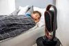 A child sleeps in bed next to a space heater. Podgląd zdjęcia produktu