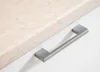 A close-up shot of a cabinet handle on a marble-like countertop. Náhled obrázku produktu
