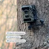 A trail camera mounted on a tree trunk, with informational overlays. Anteprima dell’immagine prodotto