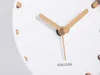 A close-up shot of a white alarm clock with wooden hands and wooden hour markers. Anteprima dell’immagine prodotto