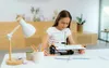 A young girl is using a drawing robot on a table. Produktbild-Vorschau