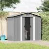 A grey metal garden shed is shown in a backyard setting, with a wooden fence and greenery in the background. Tools like a broom and a ladder are visible inside the open shed. Podgląd zdjęcia produktu