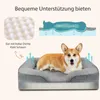 A corgi dog is lying in a gray orthopedic dog bed. The image also includes diagrams illustrating the bed's support features and a close-up of the foam material. Produktbild-Vorschau