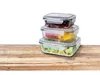 A stack of three glass food storage containers filled with different foods, placed on a wooden surface. Produktbild-Vorschau