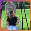 A couple enjoying a swing chair in a grassy outdoor setting. Náhled obrázku produktu