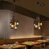 Two vintage-style chandeliers hang above tables in a restaurant setting. Produktbild-Vorschau