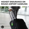 A person in a suit is pulling a black suitcase with a green TSA lock attached. Produktbild-Vorschau