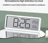 A digital clock displaying time, temperature, and humidity, placed on a reflective surface with a green background. Produktbild-Vorschau