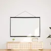 A white projection screen is hanging on a white wall above a wooden media console. Náhľad obrázku produktu