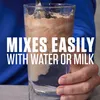 A person is mixing a powder into a glass of liquid. Produktbild-Vorschau