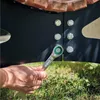 A hand is using a Bosch ratchet wrench to tighten a bolt on a black metal structure, with wooden elements visible above and grass below. Produktbild-Vorschau