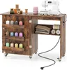 A sewing table with a sewing machine and various sewing supplies. Podgląd zdjęcia produktu