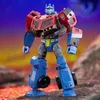 A Transformers Generations Legacy United Voyager Class Actionfigur Animated Universe Optimus Prime toy is standing on a rocky surface with a colorful, abstract background. Anteprima dell’immagine prodotto