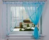 A window with blue and white curtains, showing a snowy outdoor scene.