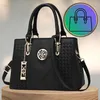 A black handbag is displayed on a wooden surface with a circular graphic overlay in the background. Produktbild-Vorschau