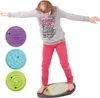 A young girl is balancing on a balance board with three different maze inserts. There are also three maze inserts displayed to the left of the girl. Produktbild-Vorschau