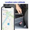 A hand is placing a small black GPS tracker into a car's center console, while a smartphone screen shows a map with the vehicle's route. Náhled obrázku produktu