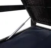 A close-up view of a gas spring mechanism supporting the lid of a brown rattan storage bench. Voir les images du produit