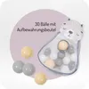 A marketing image showing a mesh bag with balls and some loose balls, with text overlay. Produktbild-Vorschau