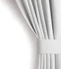 A close-up view of a white curtain, neatly folded and held by a fabric band. Produktbild-Vorschau