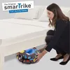 A woman is kneeling and placing a folded baby activity seat under a bed. Anteprima dell’immagine prodotto