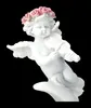 A white cherub figurine playing a violin, adorned with a pink rose wreath. Produktbild-Vorschau
