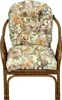 A close-up studio shot of a rattan armchair with floral cushions. Produktbild-Vorschau