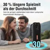 A couple is sitting at a table outdoors, looking at each other and smiling, with a portable speaker in the foreground. Produktbild-Vorschau