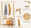 A bamboo clothing rack with two shelves, displaying clothes, baskets, and a hat. Insets highlight product features. Anteprima dell’immagine prodotto