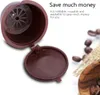 A brown coffee capsule and lid are shown, with text indicating it is refillable and reusable. Coffee beans are scattered in the background. Produktbild-Vorschau