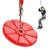 A child sits on a red disc swing, which is hanging from a rope. Anteprima dell’immagine prodotto