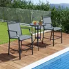 Two outdoor bar stools and a small table are set up on a wooden deck next to a swimming pool, with lush greenery and a glass fence in the background. Produktbild-Vorschau
