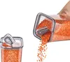 Two clear plastic food storage containers filled with orange lentils, one upright and one tilted, pouring lentils out. Produktbild-Vorschau