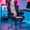 A gaming chair in a room with colorful lighting, next to a desk and shelving unit. Produktbild-Vorschau