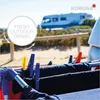 Clothes drying on a rack in front of an RV at a beach campsite. Produktbild-Vorschau