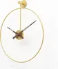 A modern, minimalist wall clock with a gold metal frame and brown hands, mounted on a white wall. Anteprima dell’immagine prodotto