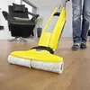 A person is using a yellow floor cleaner on a wooden floor in a modern living room with a black leather armchair in the background. Anteprima dell’immagine prodotto