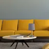 A close-up of a modern living room setting with a yellow sofa and a white coffee table. Náhled obrázku produktu