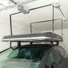 A car roof box is suspended from a ceiling lift system in a garage. Produktbild-Vorschau