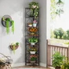 A corner shelf unit filled with various potted plants and flowers, placed next to a chair on a patio. Podgląd zdjęcia produktu