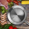 A stainless steel frying pan is placed on a wooden table, surrounded by various ingredients like raw meat, shrimp, crawfish, lettuce, corn, tomatoes, and parsley. Produktbild-Vorschau