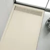 A close-up view of a modern, flat shower tray with a slate-like texture and a built-in drain. Produktbild-Vorschau