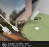 Close-up of a green and white rechargeable LED table lamp with a USB-C charging cable in the foreground, with a blurred house and sky in the background. Anteprima dell’immagine prodotto