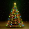 A decorated Christmas tree with colorful lights and a star on top, set against a dark, snowy background. Podgląd zdjęcia produktu