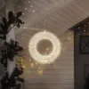 A lit-up wreath hanging from a porch ceiling, with Christmas garland and string lights. Podgląd zdjęcia produktu