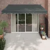 An outdoor patio scene with a dark gray awning extended over a sliding glass door. Náhled obrázku produktu