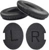 Two black ear pads and two circular inserts with L and R markings are arranged on a white background. Produktbild-Vorschau