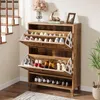 A shoe cabinet with multiple shelves and flip-down drawers, filled with shoes, placed next to a staircase and a potted plant. Podgląd zdjęcia produktu