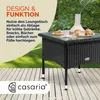 A polyrattan garden table with a glass top is shown on a wooden deck, with a grassy area and trees in the background. Croissants and a vase are on the table. Produktbild-Vorschau